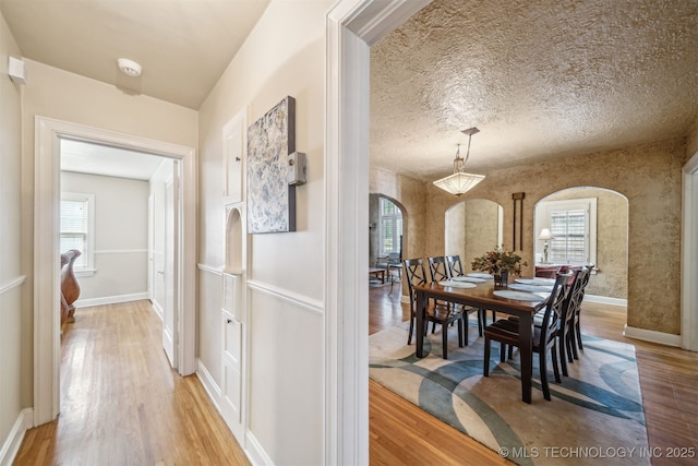 1731 S Florence Pl, Tulsa, OK 74104 - corridor featuring arched walkways, a wealth of natural light, and light wood finished floors