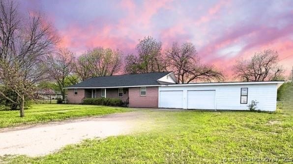 107 S 10th, Davis, OK 73030 - view of front of house with a garage, dirt driveway, and a lawn