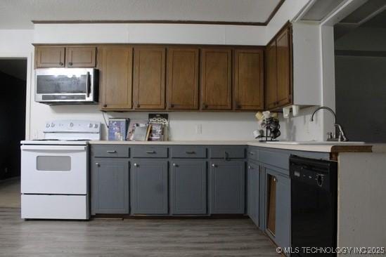 107 S 10th, Davis, OK 73030 - kitchen with stainless steel microwave, white electric stove, dishwasher, and gray cabinets