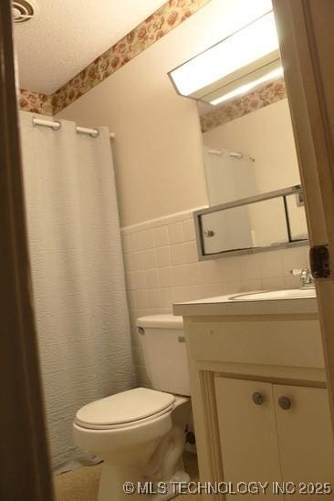 107 S 10th, Davis, OK 73030 - full bathroom with tile walls, vanity, wainscoting, and a shower with shower curtain