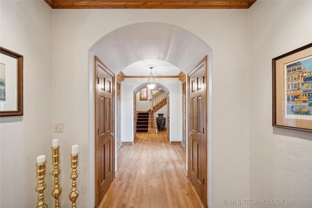 5263 Oak Leaf Dr, Tulsa, OK 74131 - corridor featuring arched walkways, crown molding, light wood finished floors, stairs, and baseboards