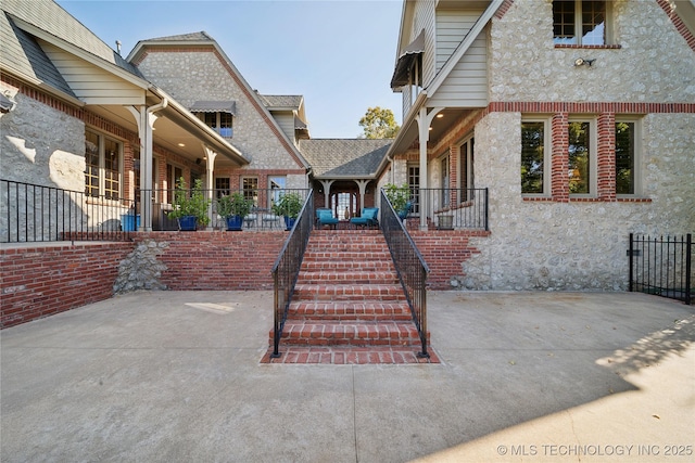 5263 Oak Leaf Dr, Tulsa, OK 74131 - view of front facade featuring brick siding, fence, a patio, and stone siding