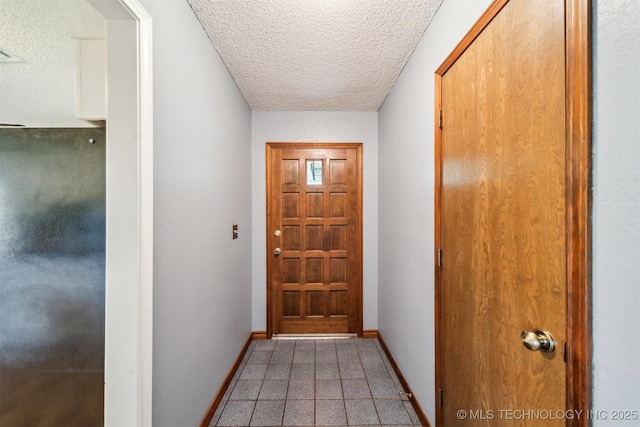 doorway with a textured ceiling and baseboards