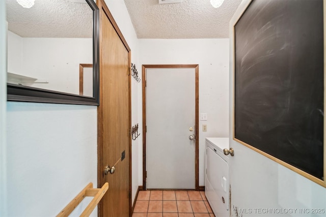 doorway featuring a textured ceiling, washer / dryer, and light tile patterned floors