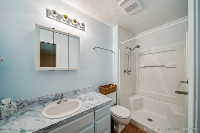 bathroom featuring a shower, vanity, and toilet