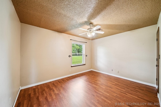 spare room featuring ceiling fan, a textured ceiling, wood finished floors, and baseboards