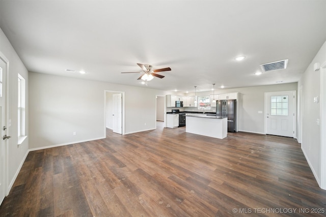 112 E Loy Ave, Chouteau, OK 74337 - unfurnished living room featuring a ceiling fan, recessed lighting, and dark wood-style flooring