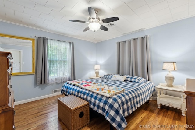 bedroom featuring wood finished floors, baseboards, and a ceiling fan