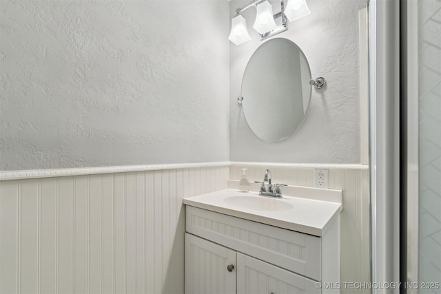 bathroom featuring vanity and a wainscoted wall