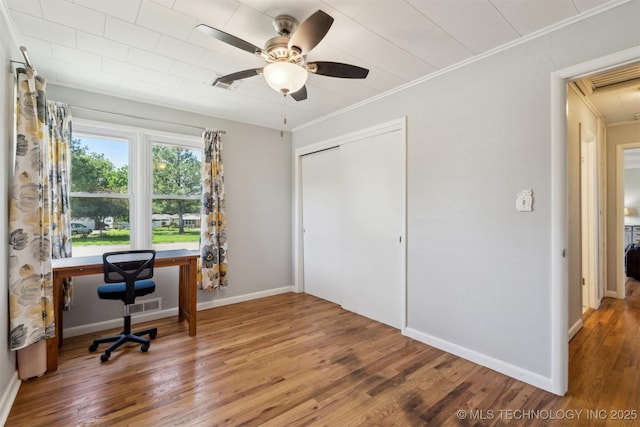home office featuring ornamental molding, wood finished floors, attic access, ceiling fan, and baseboards