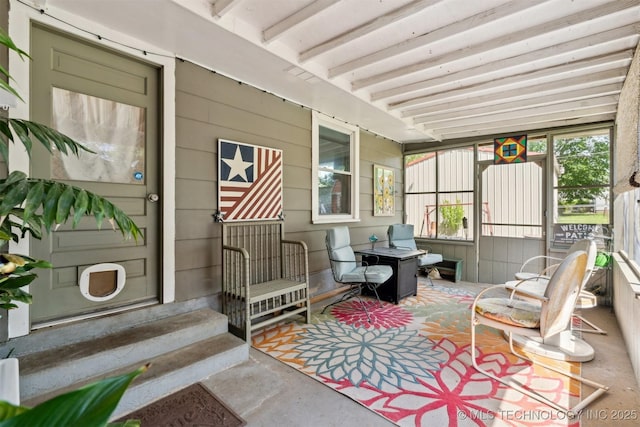 sunroom featuring beam ceiling