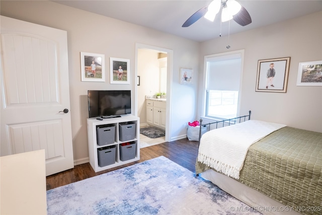 bedroom with wood finished floors, ensuite bath, and baseboards