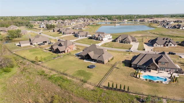 aerial perspective of suburban area with a nearby body of water and a pool area