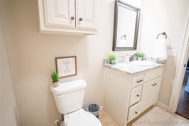 bathroom with vanity, toilet, and baseboards