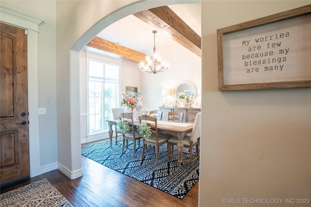 dining space featuring wood finished floors, beamed ceiling, arched walkways, baseboards, and a chandelier