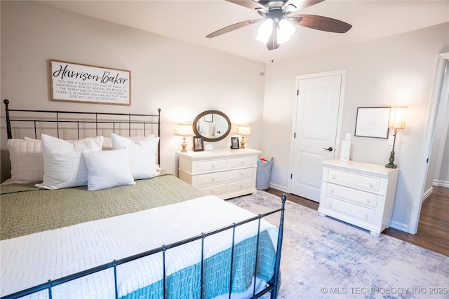 bedroom featuring baseboards, wood finished floors, and a ceiling fan