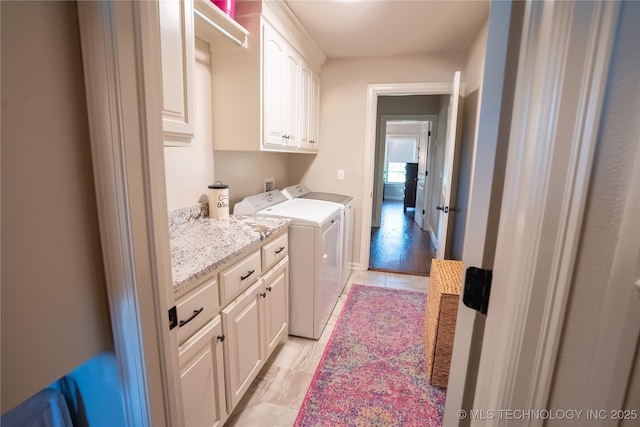 clothes washing area with cabinet space and washer and dryer