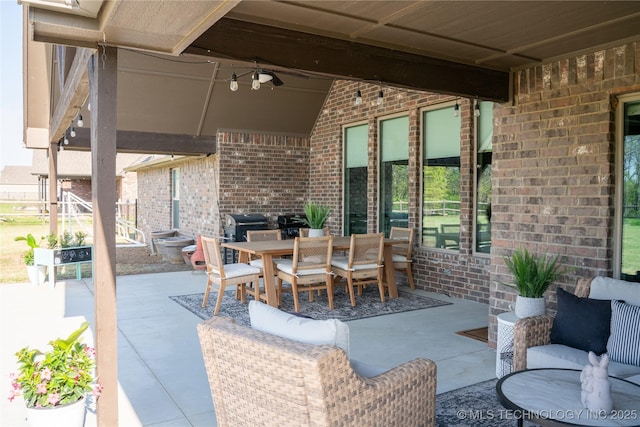 view of patio with outdoor dining area, ceiling fan, and a grill