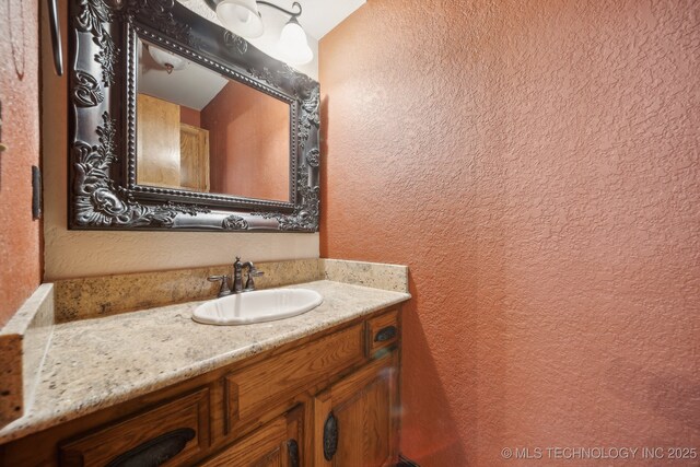 bathroom featuring a textured wall and vanity