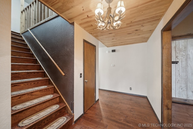 stairs featuring a chandelier, wood finished floors, wood ceiling, and lofted ceiling