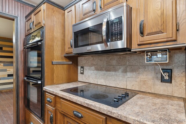 1405 W Huntsville St, Broken Arrow, OK 74011 - kitchen featuring black appliances, brown cabinets, wood finished floors, and backsplash