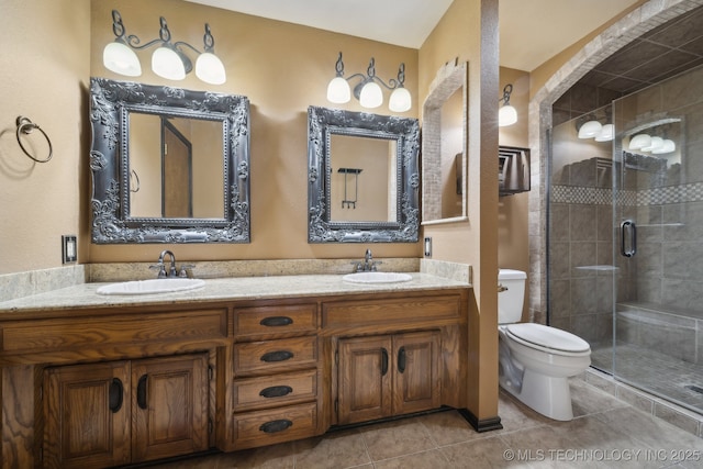 bathroom with toilet, a stall shower, double vanity, and tile patterned floors