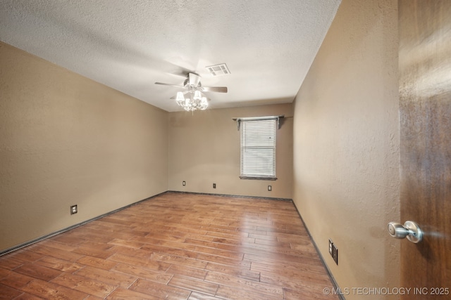 spare room with a ceiling fan, light wood-style flooring, and a textured ceiling