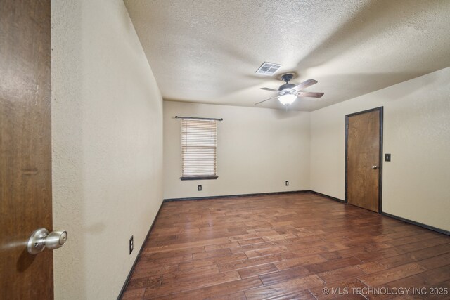 empty room with hardwood / wood-style flooring, a ceiling fan, a textured ceiling, and baseboards