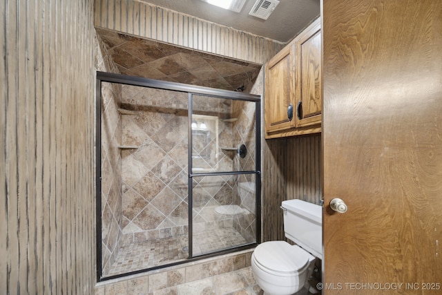 bathroom featuring toilet and a shower stall