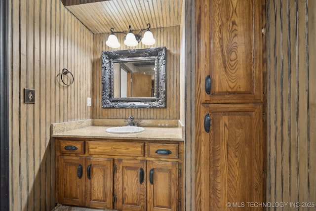 bathroom featuring vanity and wood walls