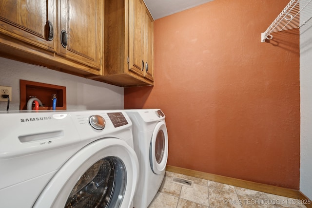 laundry room featuring cabinet space, washer and clothes dryer, baseboards, light stone finish flooring, and a textured wall
