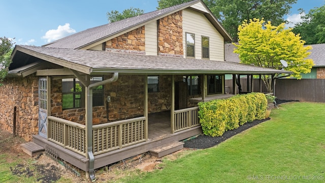 back of house featuring stone siding and roof with shingles