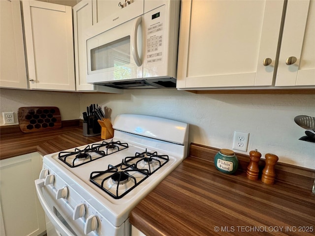 kitchen featuring white appliances and white cabinetry