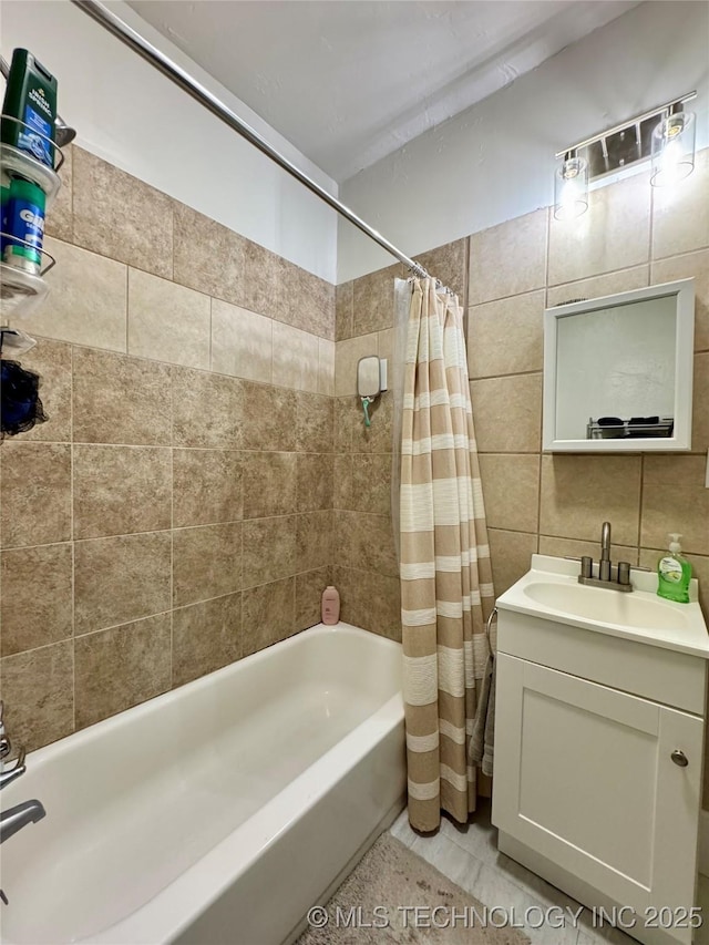 full bathroom with shower / bath combo with shower curtain, tile walls, tasteful backsplash, and vanity
