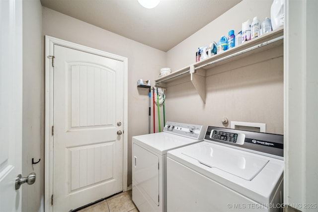 clothes washing area featuring washer and dryer and light tile patterned flooring