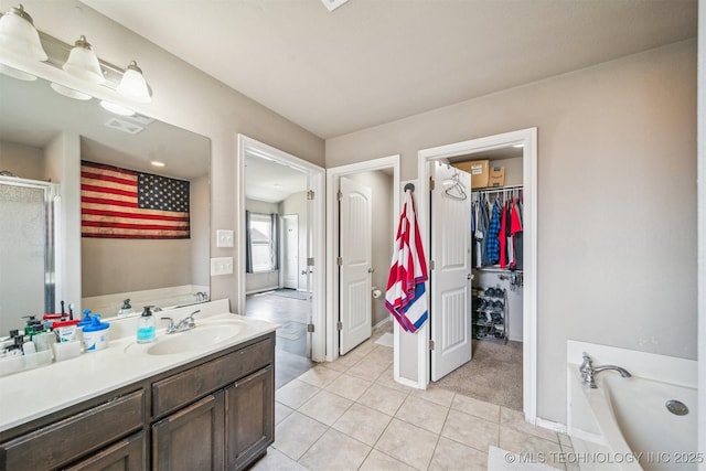 full bath with tile patterned flooring, vanity, a garden tub, a spacious closet, and a stall shower
