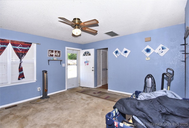bedroom with baseboards, a textured ceiling, carpet floors, and a ceiling fan