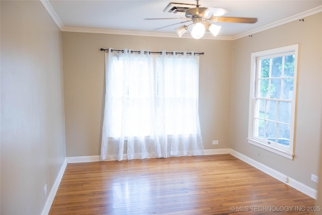 empty room with ceiling fan, wood finished floors, baseboards, and crown molding