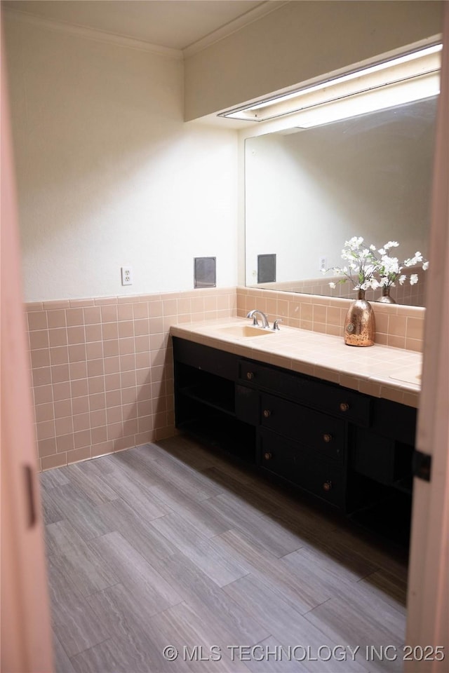 bathroom featuring crown molding, tile walls, and vanity
