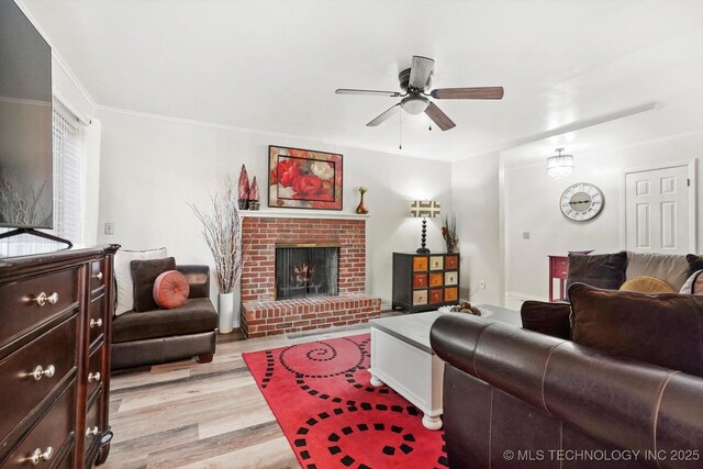 living room with ceiling fan, light wood-style flooring, and a brick fireplace