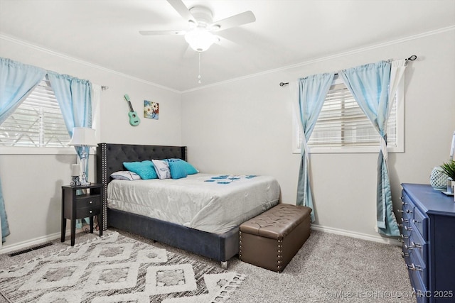 carpeted bedroom featuring baseboards, crown molding, and ceiling fan
