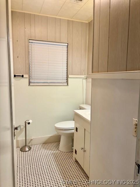 bathroom with toilet, vanity, and tile patterned floors