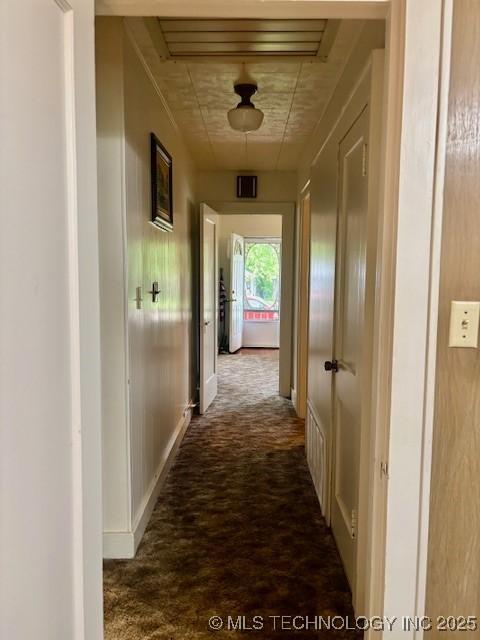 hallway with carpet flooring and baseboards