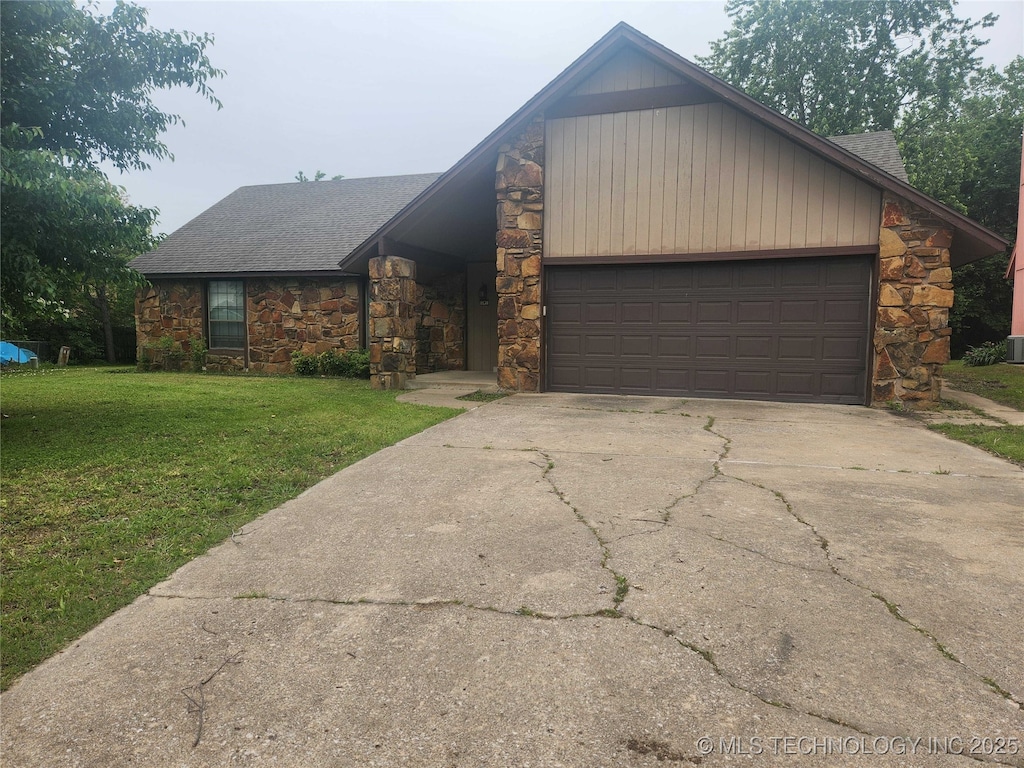 view of front of house featuring stone siding, concrete driveway, a front lawn, and a garage