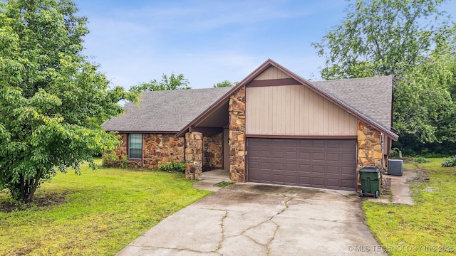 8722 N 121st Ave E, Owasso, OK 74055 - mid-century modern home with stone siding, roof with shingles, a garage, a front lawn, and concrete driveway