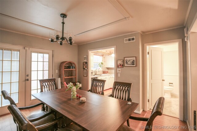 5518 E 46th St Unit 5518, Tulsa, OK 74135 - dining area with a chandelier, light wood-style flooring, healthy amount of natural light, crown molding, and french doors