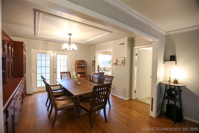 5518 E 46th St Unit 5518, Tulsa, OK 74135 - dining area featuring wood finished floors, a chandelier, baseboards, and ornamental molding