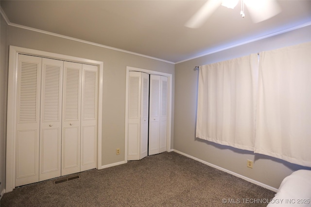 5518 E 46th St Unit 5518, Tulsa, OK 74135 - unfurnished bedroom featuring multiple closets, dark carpet, baseboards, ornamental molding, and ceiling fan