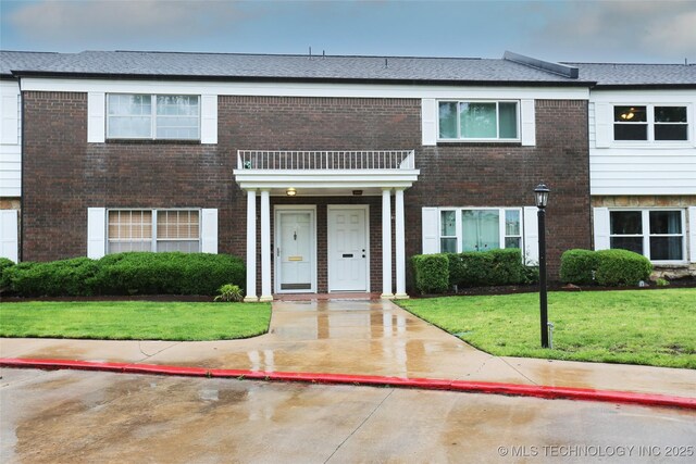 5518 E 46th St Unit 5518, Tulsa, OK 74135 - view of property featuring a balcony, brick siding, and a front lawn