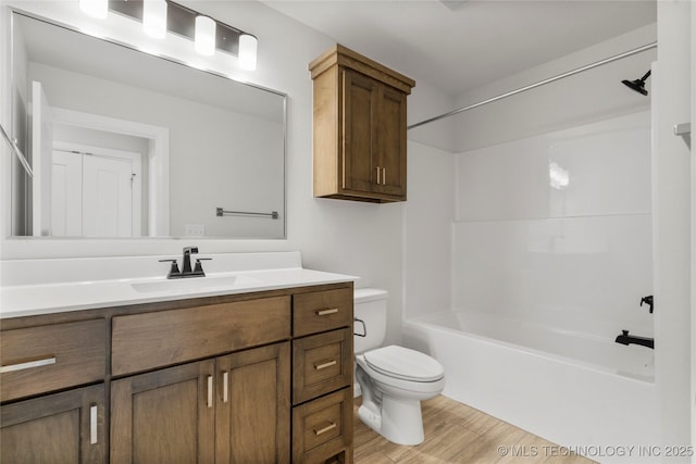 full bath featuring toilet, wood finished floors, vanity, and tub / shower combination
